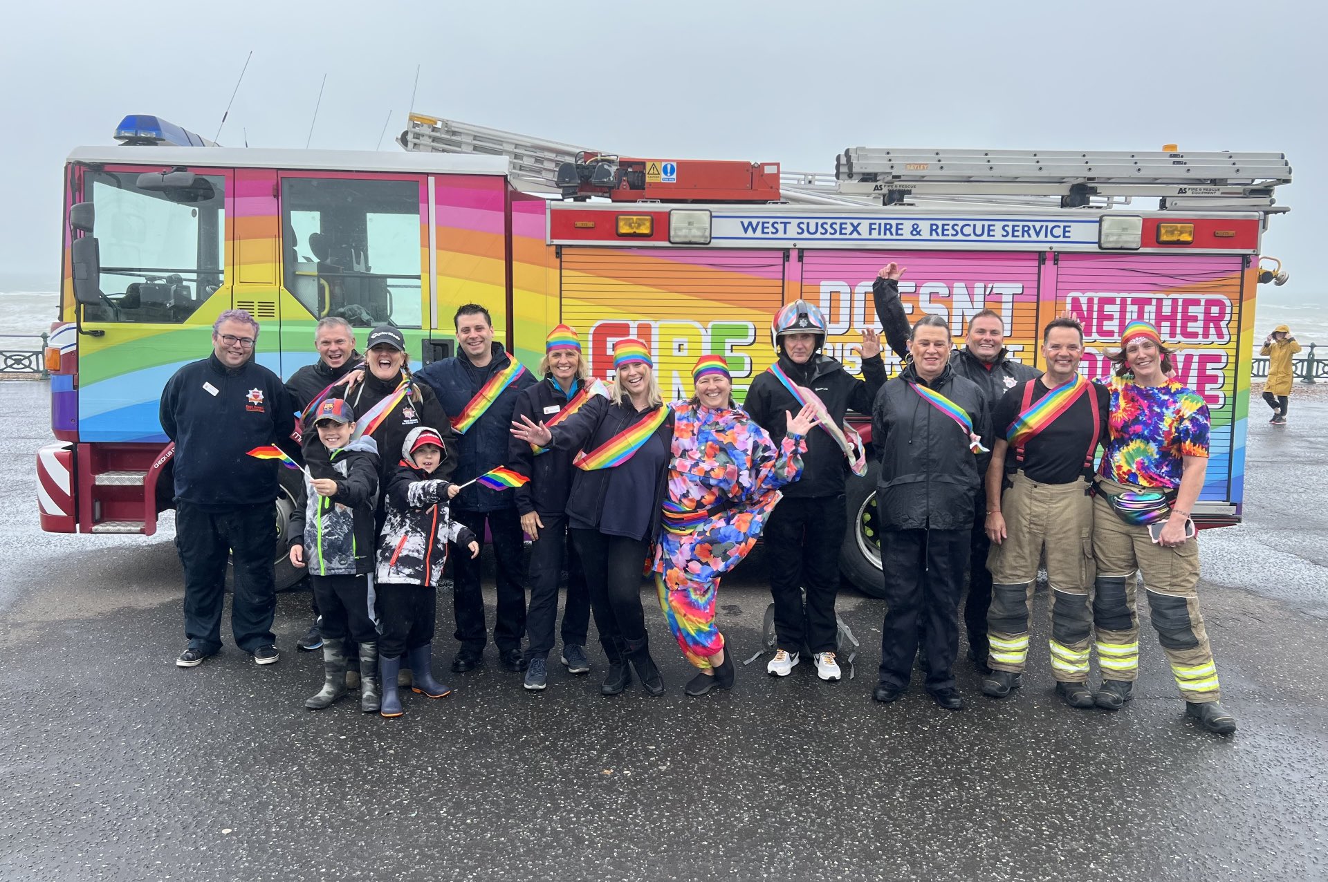 Photo of various members of staff including firefighters and volunteers in front of West Sussex wrapped Pride appliance for Brighton Pride
