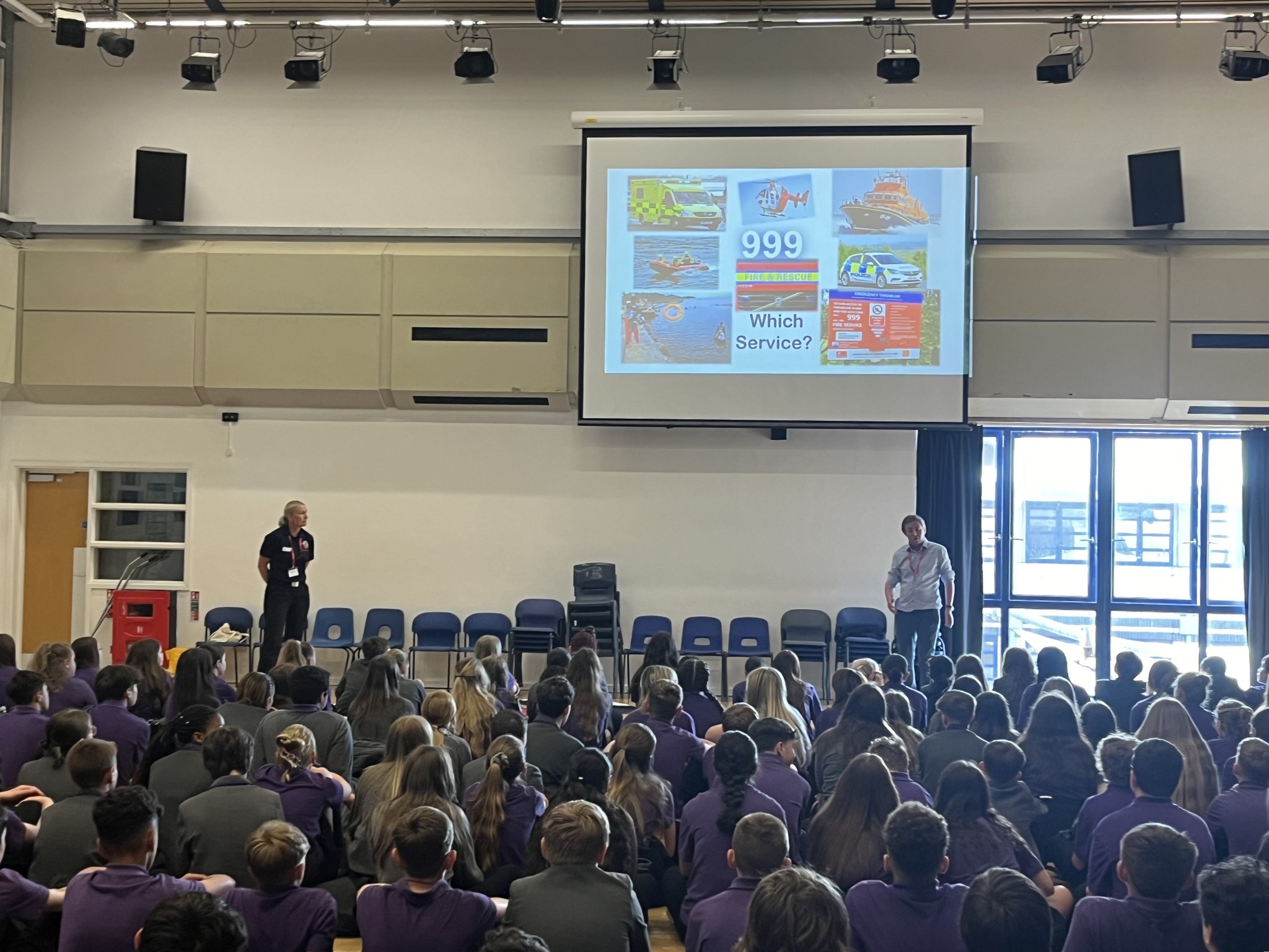 Photo of school children facing two people providing a water safety education presentation.