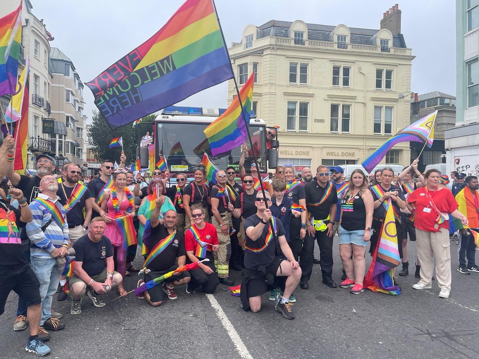 A crowd of people in Brighton representing ESFRS waving rainbow flags